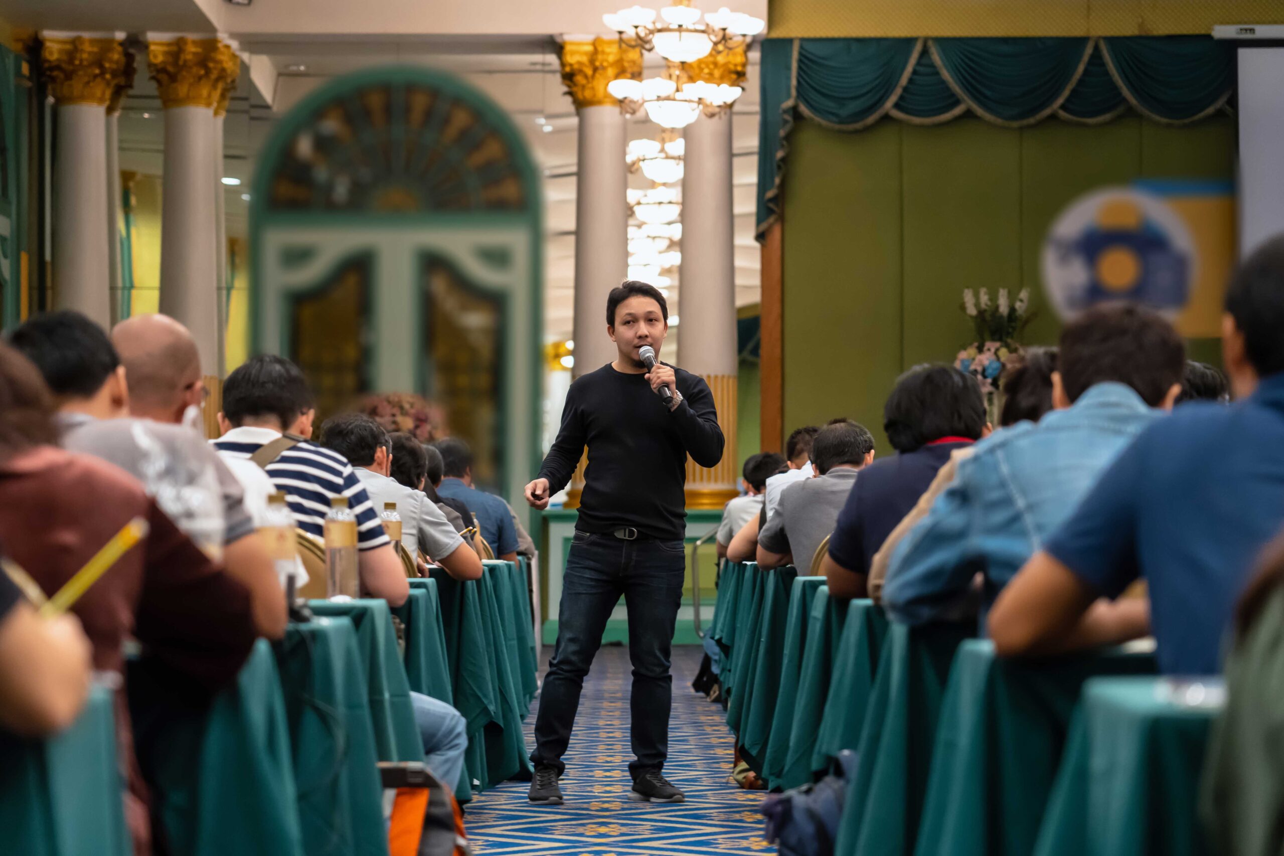 asian-speaker-with-casual-suit-standing-and-giving-2022-12-16-03-27-51-utc